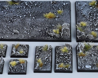 May include: A set of 10 black and white textured square gaming terrain tiles with a rocky and grassy surface. The tiles are designed for use in tabletop wargames and miniature gaming.