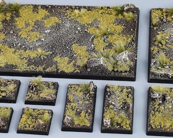 May include: A set of 12 square terrain tiles for tabletop gaming. The tiles feature a variety of textures and colors, including green grass, brown dirt, and gray rocks. The tiles are designed to be used together to create a realistic and detailed battlefield.
