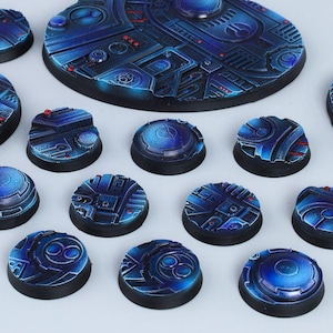 May include: A set of 14 blue and black plastic gaming bases with a futuristic design. The bases are in various shapes and sizes, including round, oval, and rectangular. The bases are decorated with intricate details, including lines, circles, and squares. The bases are perfect for use with miniature wargaming figures.