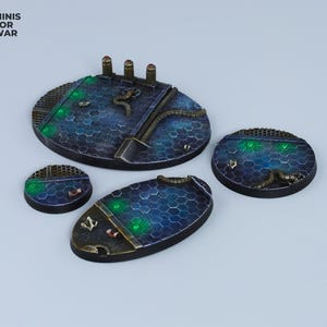 May include: Four round, blue and black, textured, resin gaming bases with green glowing accents. The bases are designed for miniature wargaming.