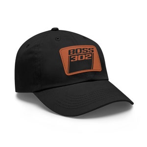 May include: A black baseball cap with a brown leather patch that says "BOSS 302" in black lettering.