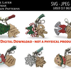 May include: A collection of double-layer Christmas keychain patterns. The designs include a Christmas tree, candy cane, bells, a gift, a snowflake, and an elf. Each keychain has a metal clasp and a tassel. The text on the keychains includes phrases like "And I'm feelin' fine".