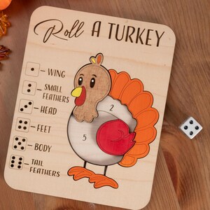 May include: Wooden "Roll a Turkey" game board with a cartoon turkey illustration. The board features a dice game with numbered sections for different turkey parts. The text "Roll a Turkey" is at the top.