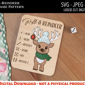 May include: A wooden Roll-a-Reindeer dice game pattern with a cartoon reindeer illustration. The game board features a reindeer wearing a hat and scarf, with dice roll instructions. The text "Roll a Reindeer" is at the top.