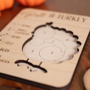 May include: Wooden turkey puzzle with numbered cutouts for body parts. The puzzle includes separate orange feather pieces and is designed for educational play. The text "Spirit of Turkey" is visible on the puzzle.