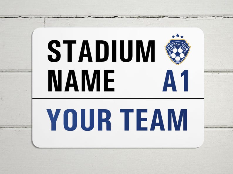 May include: White sign with blue and gold text and a blue and gold soccer ball logo. The sign reads "STADIUM NAME A1 YOUR TEAM".