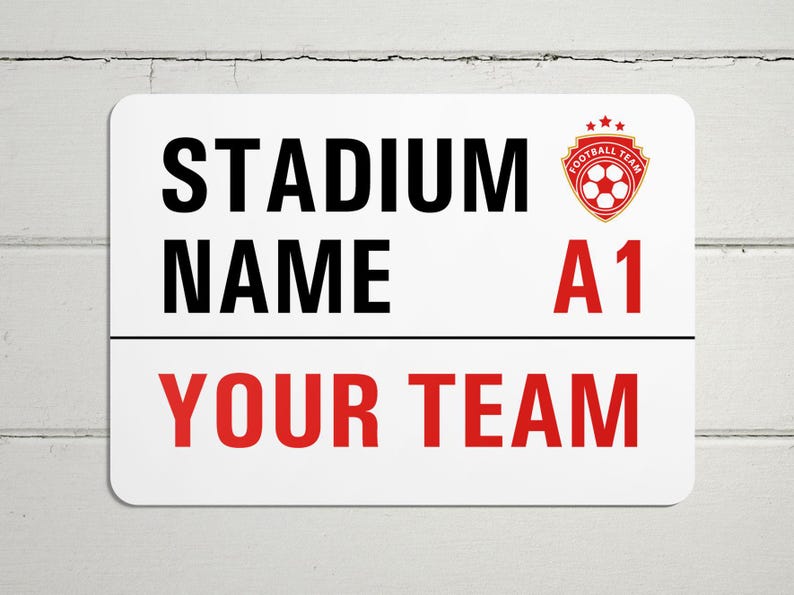 May include: White sign with black text that reads "STADIUM NAME A1 YOUR TEAM". A red and gold soccer logo is in the top right corner.