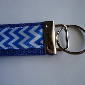 May include: Blue and white chevron patterned key chain with a silver metal key ring.