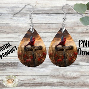 May include: Teardrop-shaped earrings featuring a red cardinal perched on a wooden cross against a sunset backdrop. The earrings have silver-colored hooks and a metallic cap. The words "DIGITAL PRODUCT" and "PNG File Download" are visible.