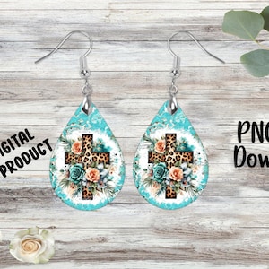 May include: A pair of teal blue teardrop-shaped earrings with a silver hook. The earrings feature a white background with a leopard print cross and floral accents.