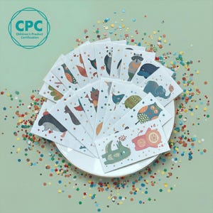 May include: A collection of white paper cards, each featuring a different animal illustration, arranged on a white plate. The illustrations include a panda, raccoon, elephant, and owl. The cards are surrounded by colorful confetti, with the text "Children's Product Certification" visible.