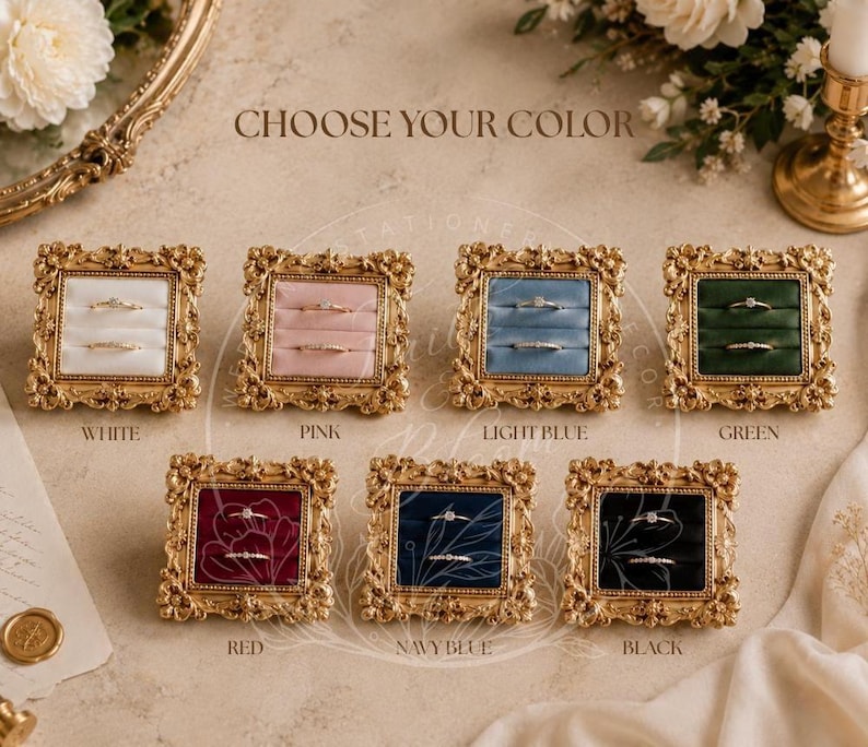 May include: Seven square ring boxes with ornate gold frames and velvet inserts in white, pink, light blue, green, red, navy blue, and black. Each box features two horizontal slots for rings and the text CHOOSE YOUR COLOR at the top.