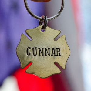 May include: A gold-colored metal keychain shaped like a fire hydrant with the name "GUNNAR" engraved on it.