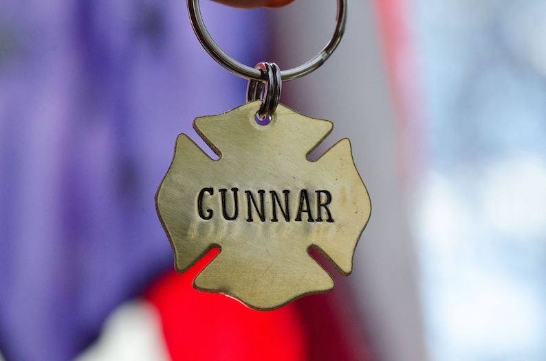 May include: A gold-colored metal keychain shaped like a fire hydrant with the name "GUNNAR" engraved on it.