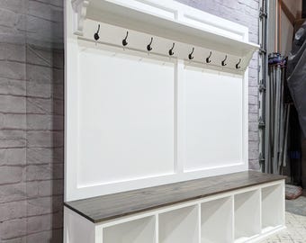 May include: White entryway bench with a shelf and hooks. The bench has four cubbies for storage and a wood top.