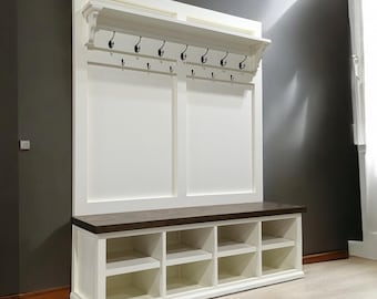 May include: White entryway bench with a brown top, open shelves, and hooks for hanging coats. The bench has a white painted finish and a dark wood top.
