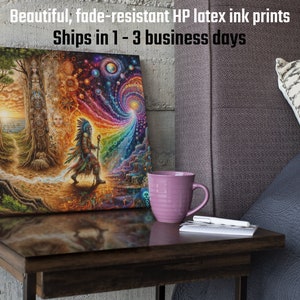 May include: A colorful canvas print featuring a Native American figure walking towards a swirling vortex of light and color. The print is framed and displayed on a wooden table next to a purple mug and a notebook.