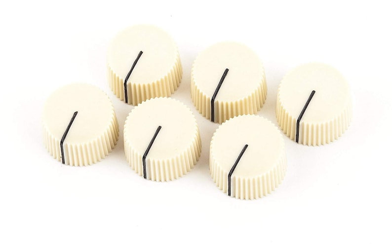 May include: Six cream-colored control knobs with a black indicator line. The knobs have a ridged, cylindrical base and a flat top. These are likely replacement parts for an electronic device.