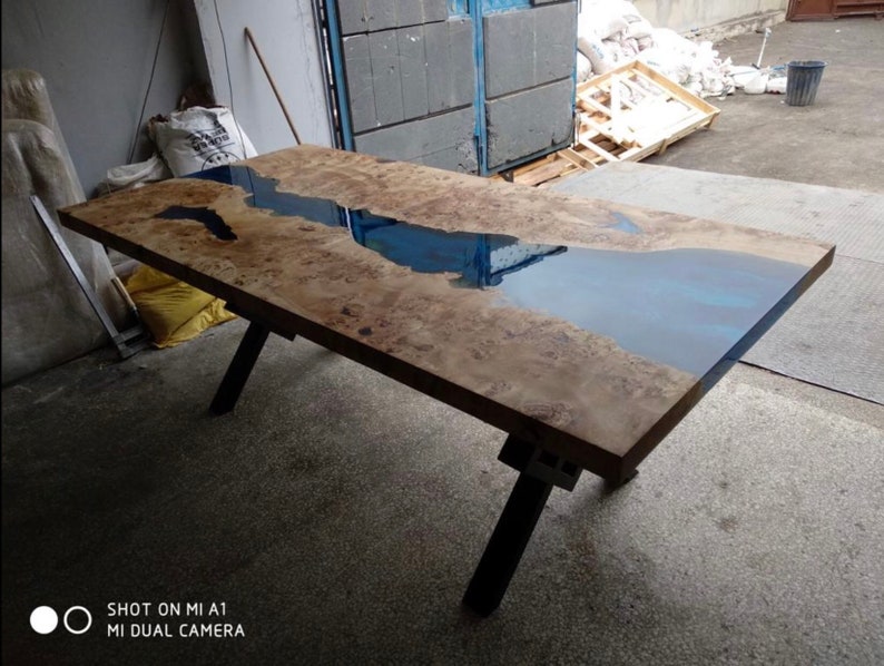 Pode incluir: Mesa retangular de madeira com design de rio de resina azul. A mesa tem um acabamento natural de gr&atilde;o de madeira e pernas de metal preto. A mesa tem aproximadamente 183 cm de comprimento e 91 cm de largura.