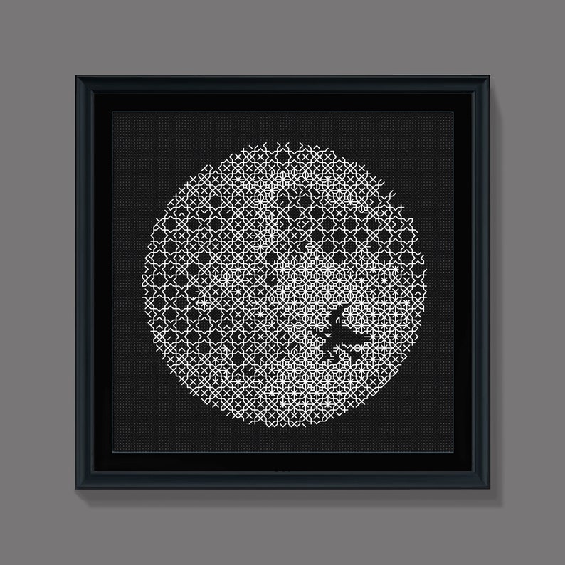 May include: A black and white framed artwork featuring a circular design with a geometric pattern. The design is made up of small white squares on a black background.