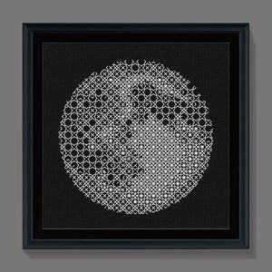 May include: A black and white framed artwork featuring a circular design with a geometric pattern. The design is made up of white lines on a black background.