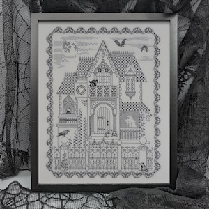 May include: Black and white cross-stitch of a spooky house with a decorative border, framed in black. The house features a cat, bats, a ghost, and a pumpkin. The design is perfect for Halloween decor.