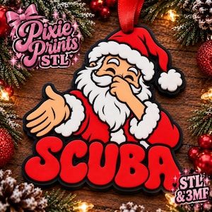 May include: A Christmas ornament featuring a cartoon Santa Claus dabbing, with the word SCUBA in bold red letters below. The design includes a red hat, white beard, and black outline, suspended by a red ribbon against a festive holiday background.