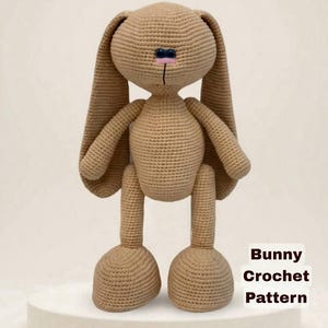 Peut inclure: Un lapin en crochet beige avec de longues oreilles, des yeux sombres et un nez brodé rose. Le texte MOLLY FRIENDS apparaît en haut et le texte Bunny Crochet Pattern est visible en bas à droite. Le jouet a une tête et un corps ronds.