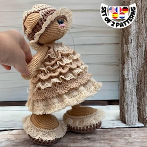 May include: Crocheted doll wearing a brown and beige dress with a white lace trim and a brown crocheted hat with a white lace trim. The doll is standing on a wooden surface. The image includes the text "Set of 2 Patterns".