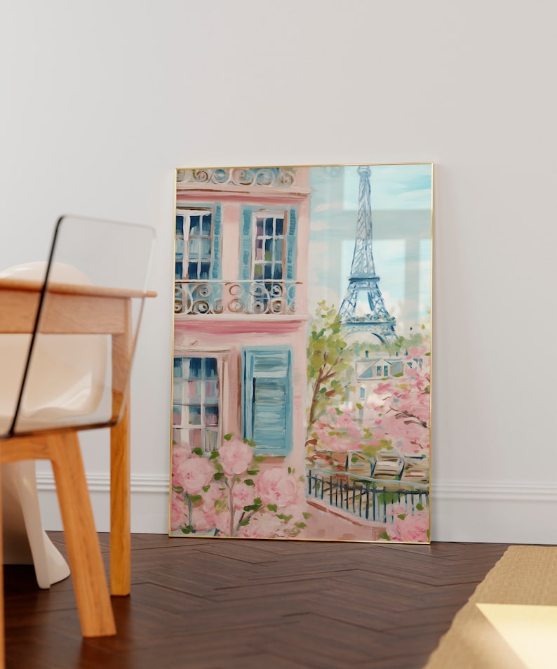 Pu&ograve; includere: Un dipinto di un edificio rosa con persiane blu e un balcone. La Torre Eiffel &egrave; visibile sullo sfondo. Ci sono fiori rosa in primo piano.