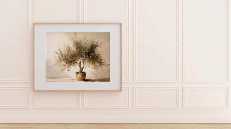 May include: A framed print of an olive tree in a terracotta pot. The artwork is set against a neutral background, with a light wood frame. The wall is painted a soft pink with decorative molding.