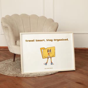 May include: A framed horizontal print featuring a yellow cartoon folder character with arms and legs, wearing blue sneakers. The text reads "Travel Smart, Stay Organized." at the top and "2000 PARIS FRANCE" at the bottom in a brown sans-serif font.