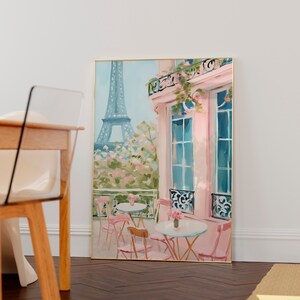 May include: A watercolor painting of a Parisian cafe with pink walls and a view of the Eiffel Tower. The cafe has tables and chairs set up outside, with pink flowers in pots.