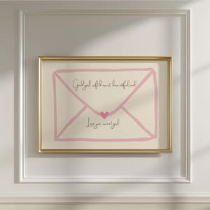 Puede incluir: Obra de arte enmarcada con un diseño de sobre rosa con las palabras "Good girl, soft heart, beautiful soul" y "Love you, sweet girl" en escritura negra. Un pequeño corazón rosa está centrado en el sobre.