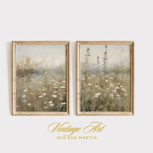 May include: Two vintage framed paintings of a field of wildflowers in a soft, muted color palette. The paintings are in light wood frames with a whitewash finish.