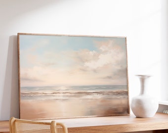May include: A framed painting of a seascape with a light blue sky, white clouds, and a sandy beach with waves crashing on the shore. The painting is hanging on a white wall above a wooden desk with a chair and a white vase.