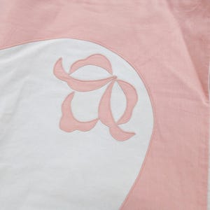 May include: A pink and white fabric with a pink floral design. The fabric is made of a soft, lightweight material and is perfect for crafting projects.