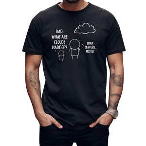 Puede incluir: Camiseta negra con un gráfico humorístico. El gráfico presenta figuras de palo y el texto "DAD, WHAT ARE CLOUDS MADE OF?" y "LINUX SERVERS, MOSTLY". El diseño incluye una ilustración de nube.