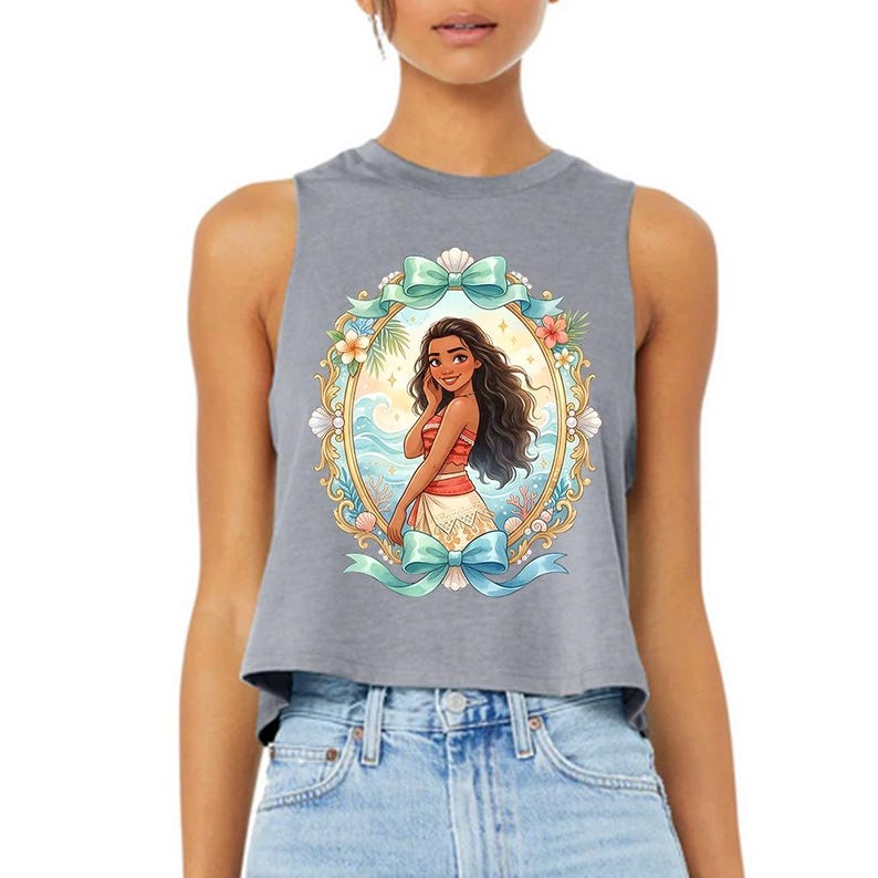 Puede incluir: Un top corto sin mangas gris con una ilustraci&oacute;n enmarcada de una mujer con cabello largo y oscuro, vestida con un atuendo rojo y blanco. El marco incluye conchas marinas, flores y lazos color turquesa. La ilustraci&oacute;n est&aacute; centrada en la parte superior.