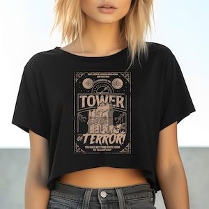 May include: Black crop top with a vintage-style graphic that reads "TOWER OF TERROR!" in a distressed font. The design includes an illustration of a tower and the text "YOU MAY NOT COME BACK FROM THE TWILIGHT ZONE."