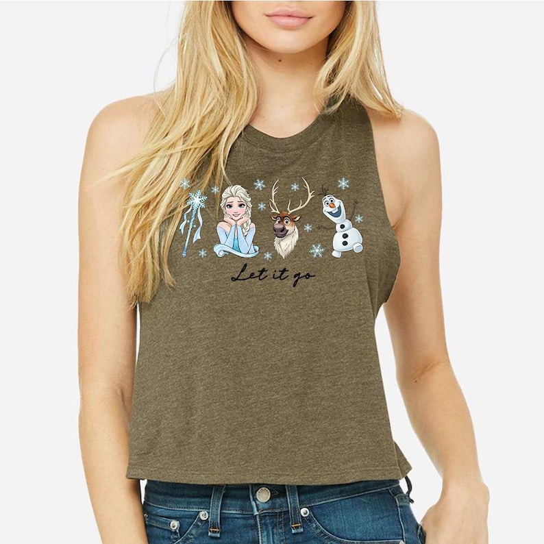 Pu&ograve; includere: Canotta verde oliva con una grafica di Elsa, Sven e Olaf di Frozen, fiocchi di neve e la scritta "Let it go". Il design &egrave; nei toni del blu, bianco e marrone.