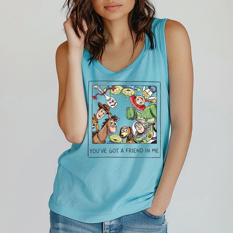 May include: A turquoise tank top with a framed graphic of Toy Story characters. The graphic includes Woody, Buzz Lightyear, and other characters. The text "YOU'VE GOT A FRIEND IN ME" is printed below the graphic.