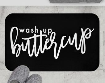 May include: Black bath mat with white text that reads "Wash up buttercup".