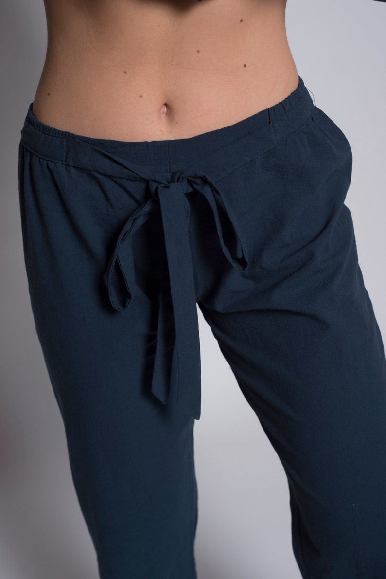 May include: Dark blue pants with a tie at the waist.