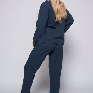 May include: A dark blue pajama set with long sleeves and pants. The top has a white trim around the collar and cuffs.