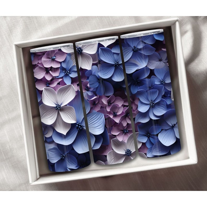 May include: Three stainless steel tumblers with a floral design. The tumblers are decorated with a pattern of blue and purple flowers.