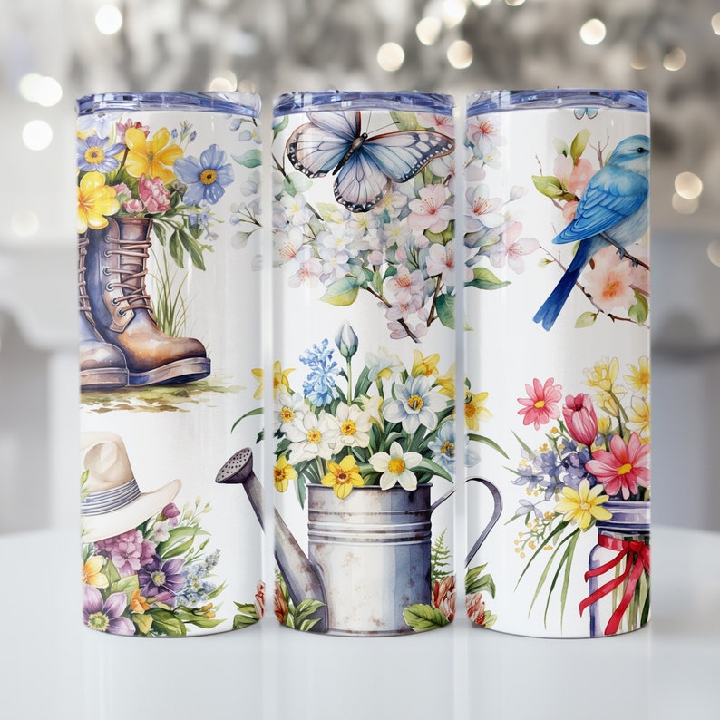 May include: Three stainless steel tumblers with different floral designs. The first tumbler features a bouquet of flowers, a pair of boots, and a hat. The second tumbler features a butterfly, flowers, and a watering can. The third tumbler features a bluebird, flowers, and a jar with a red ribbon.