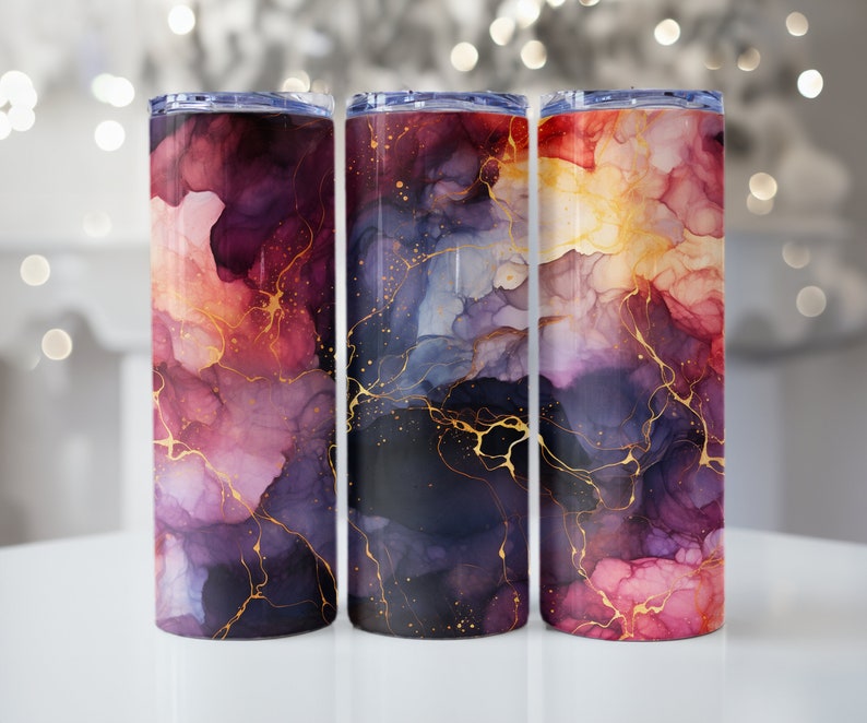 May include: Three stainless steel tumblers with a colorful abstract design. The tumblers feature a swirling pattern of pink, purple, blue, and gold.