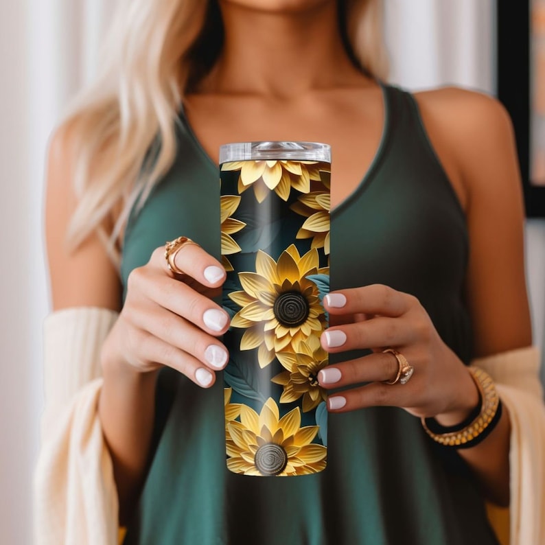 May include: A stainless steel tumbler with a sunflower design. The tumbler has a black background with yellow and green sunflowers.