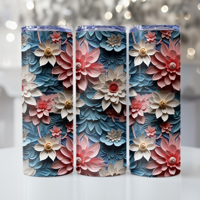 May include: Three stainless steel tumblers with a floral design. The tumblers feature a blue background with pink and white flowers.